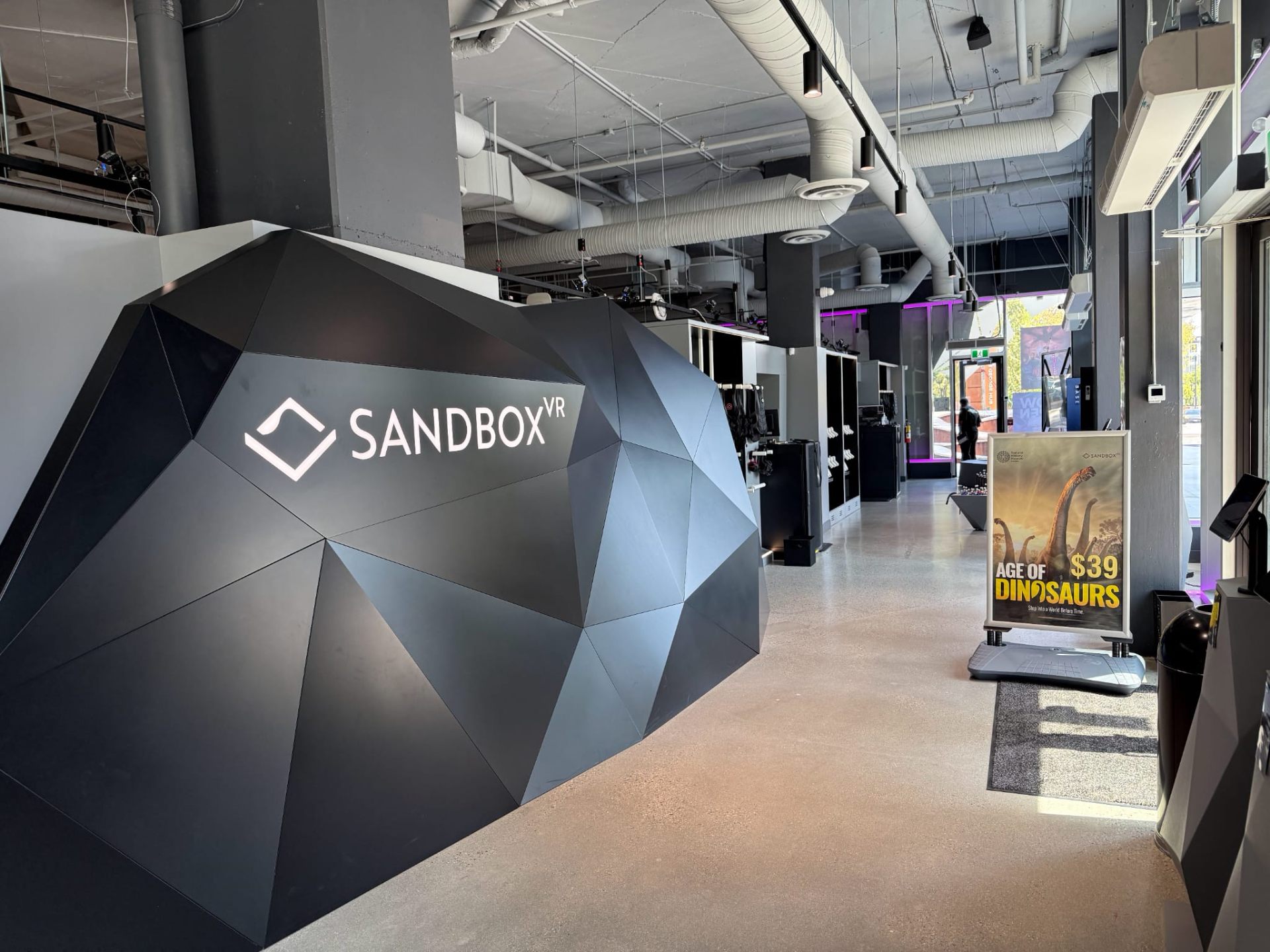 Finished Sandbox VR Surrey lobby with branded faceted reception feature