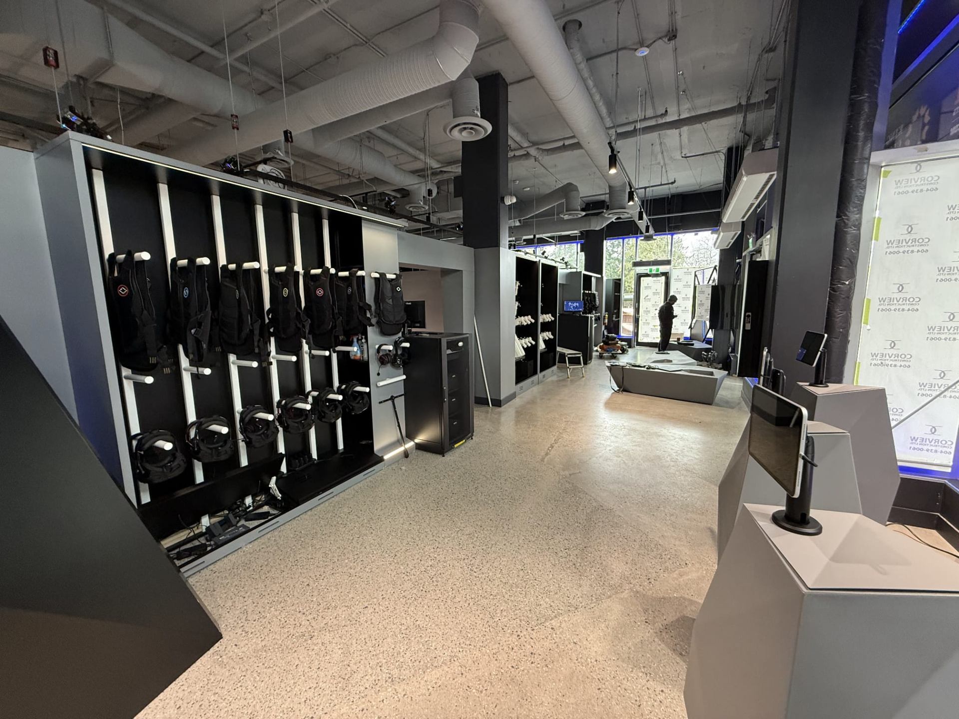 Completed Sandbox VR gear wall with vests, headsets, and check-in stations