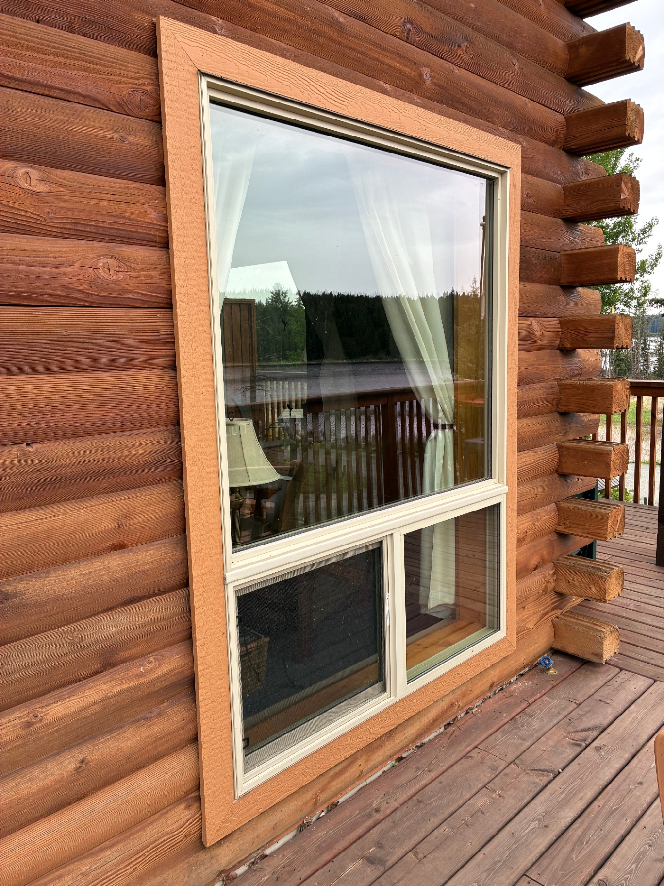 Exterior cabin window with new trim and lake view reflection