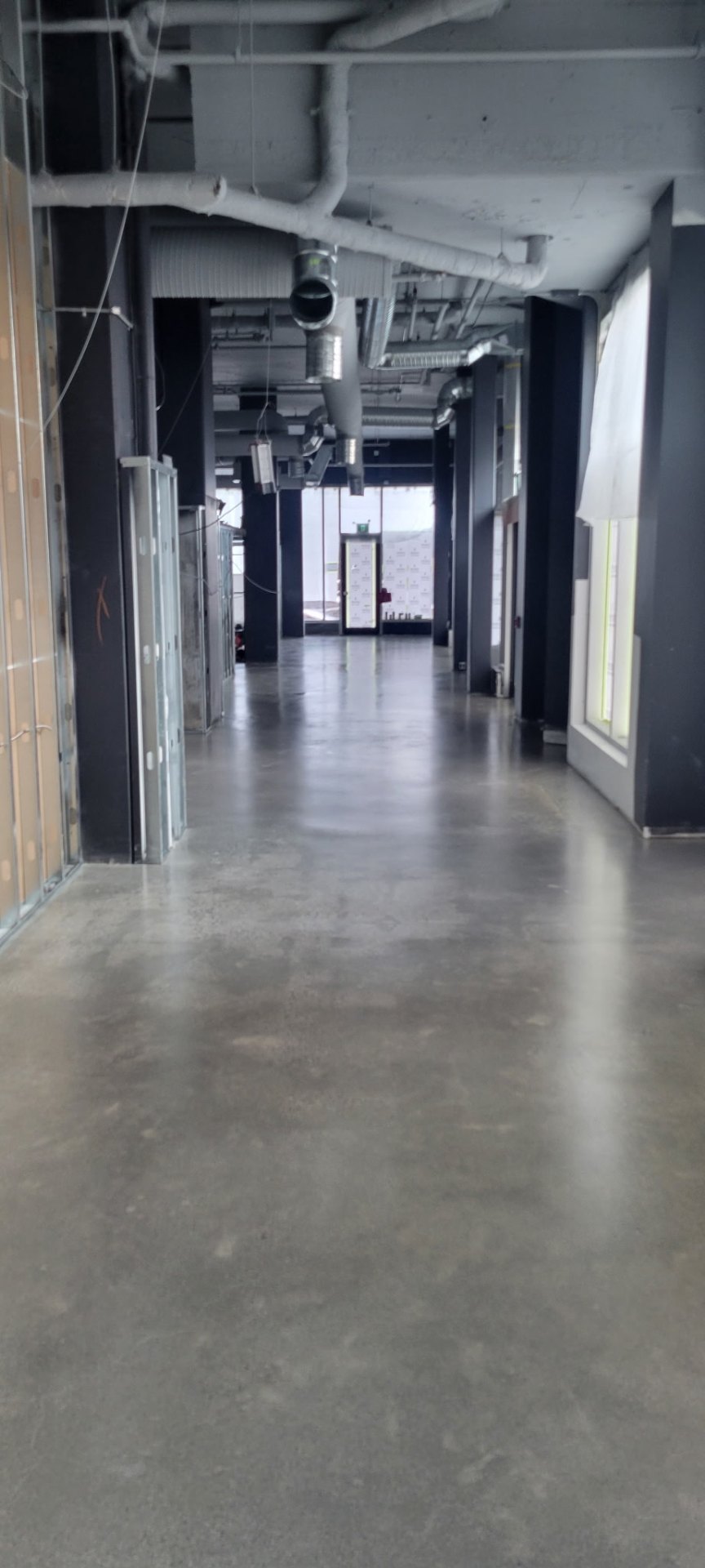 Polished concrete corridor through the completed Sandbox VR Surrey space