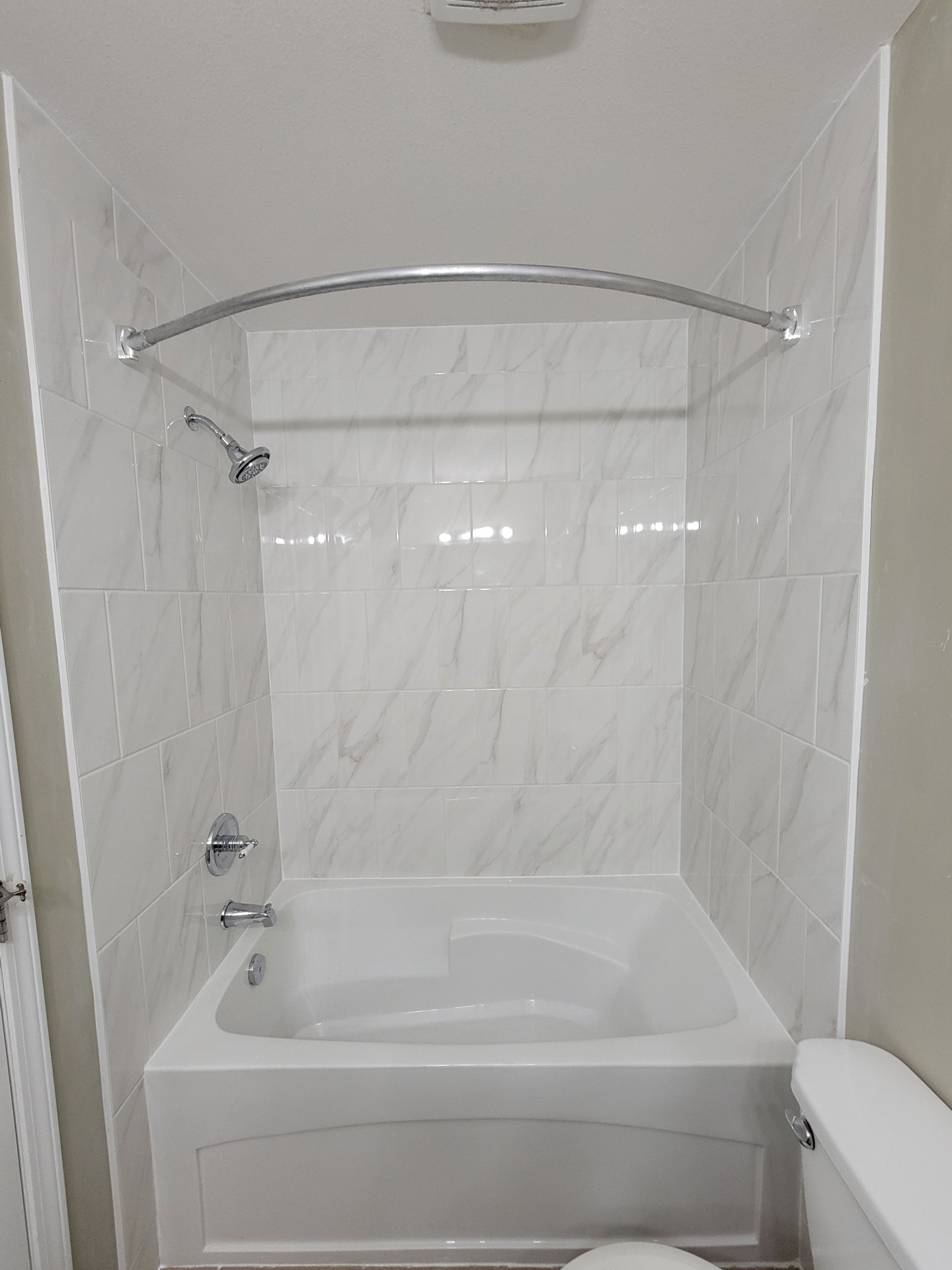 Renovated tub and shower with marble-look tile surround