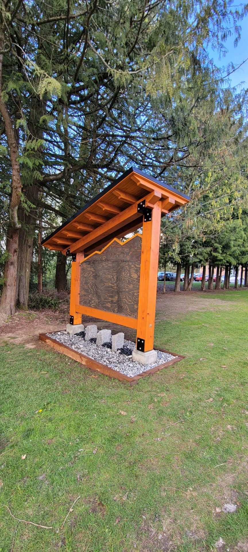 Back view of trail billboard structure with cedar posts and stone base