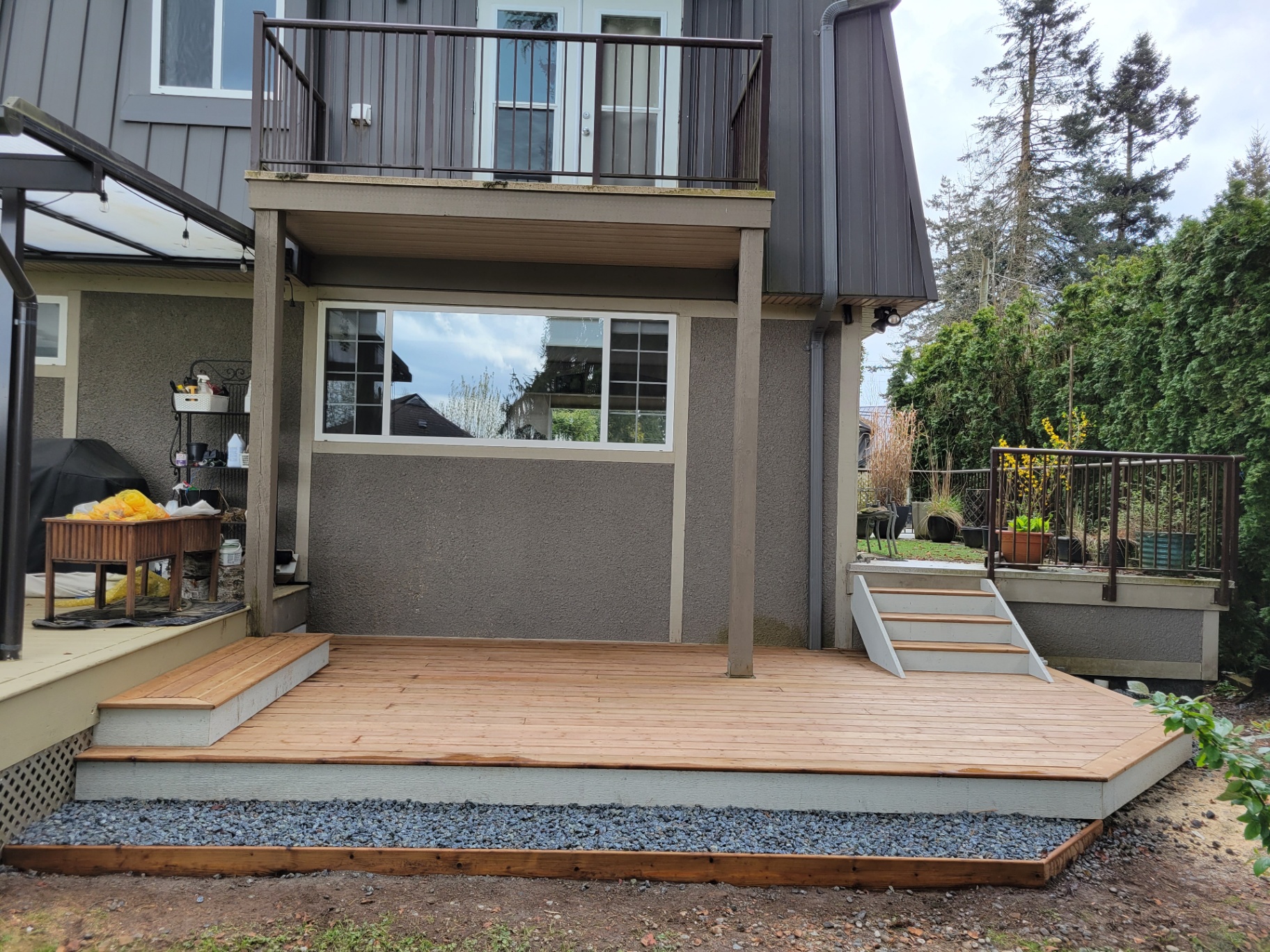 Cedar deck addition with side stairs and gravel border