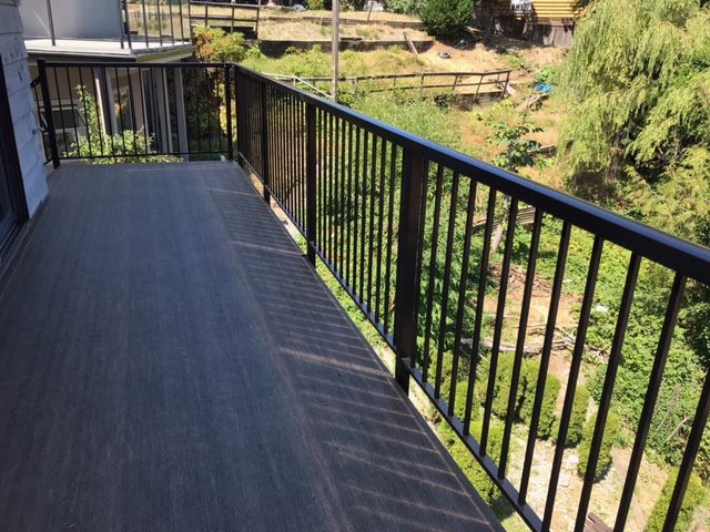 Long view of finished deck walkway with black railing