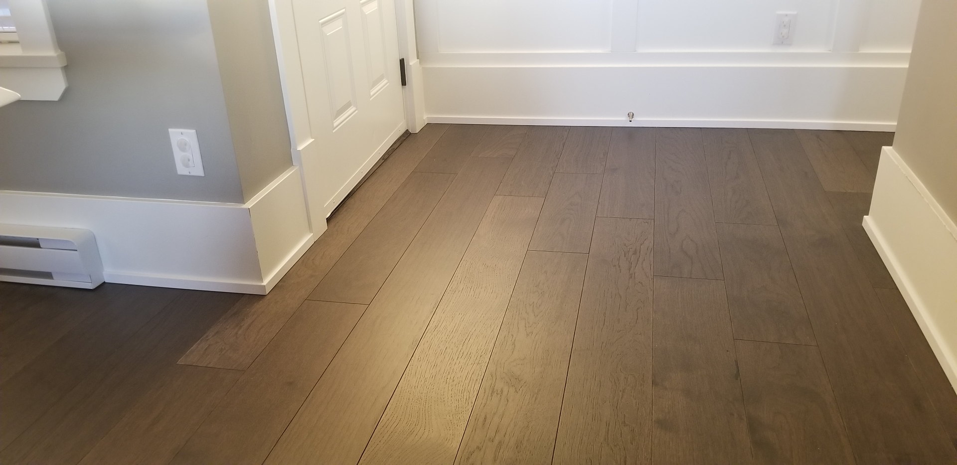 Hallway and room entry with new wide-plank hardwood flooring and white trim