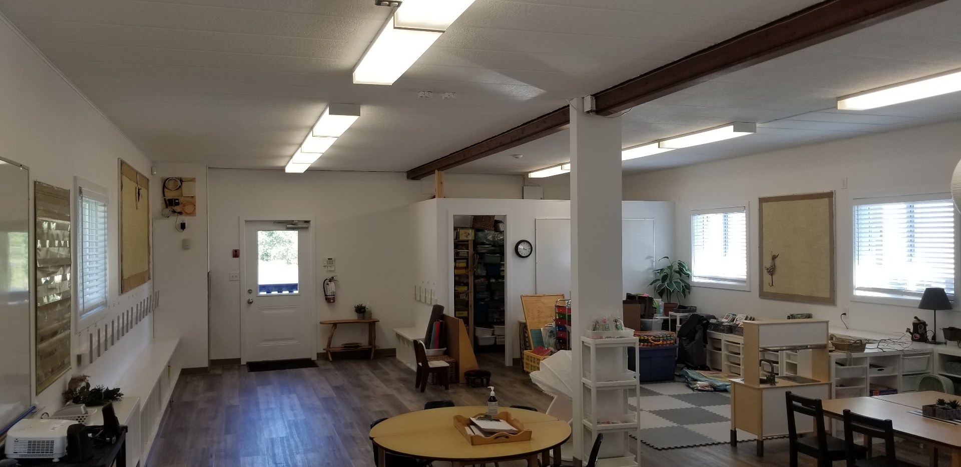 Wide view of finished classroom with entry door and learning zones